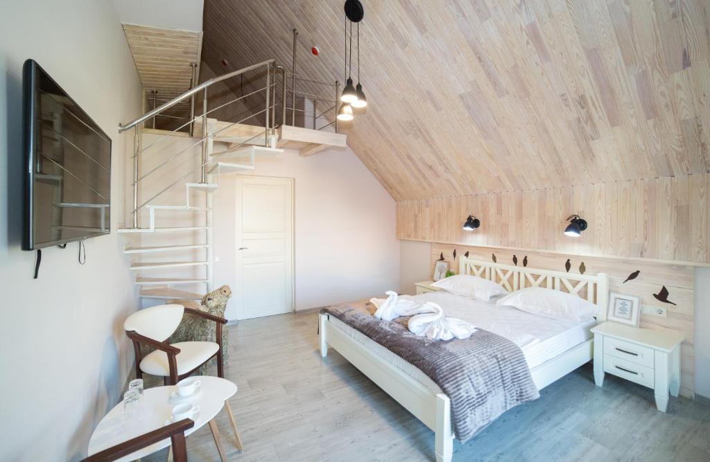 ein Schlafzimmer mit einem Bett und einer Holzdecke in der Unterkunft Ministerka Lake-House in Kiew