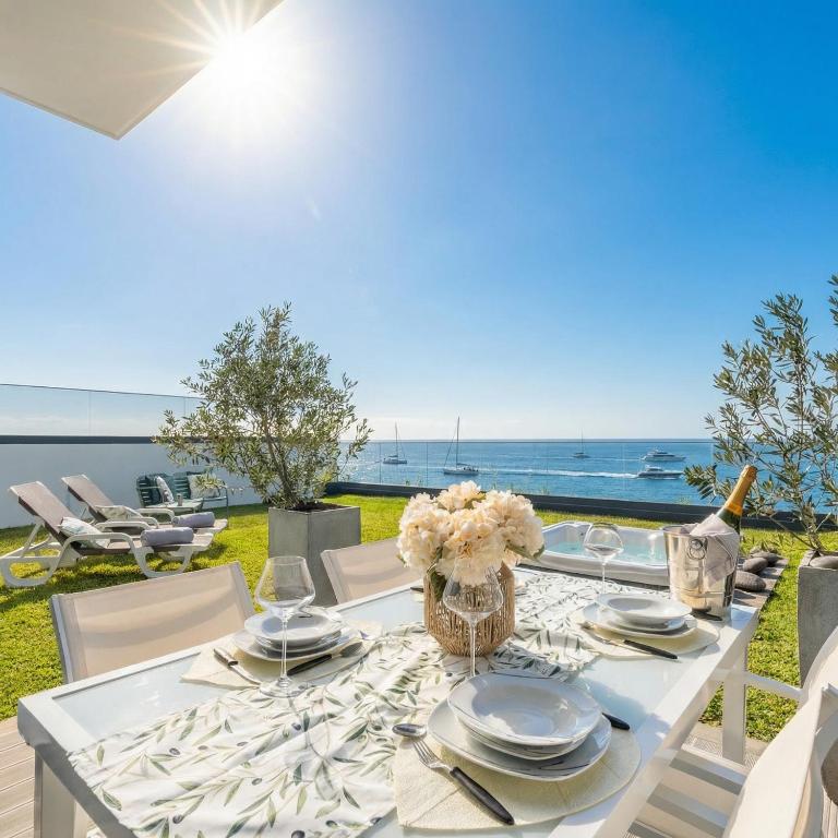 a white table with a vase of flowers on it at Luna do Mar - Luxury apt with Jacuzzi in Gaula