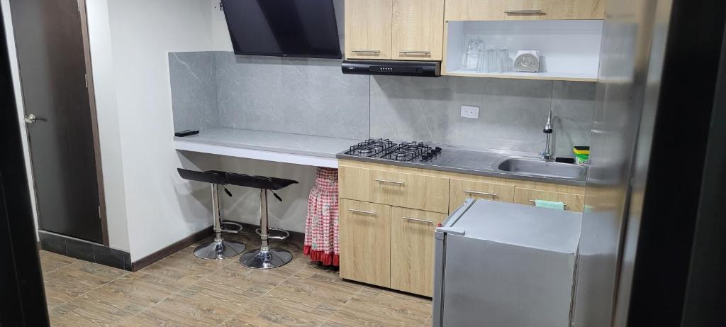 a small kitchen with a sink and a stove at Apto con balcon in Pasto