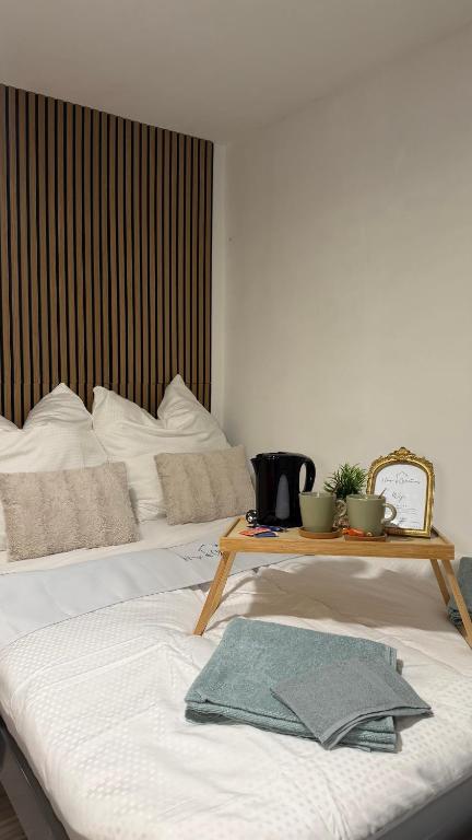 two beds in a room with a table on top at Zentrale Gästezimmer am Marienplatz- Paris in Stuttgart