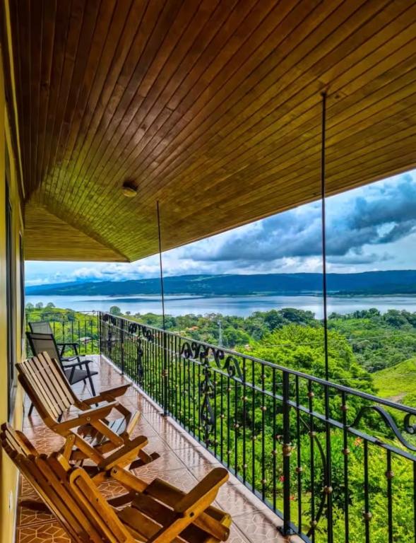 a balcony with chairs and a view of the forest at Villa Esperanza El Castillo in Fortuna