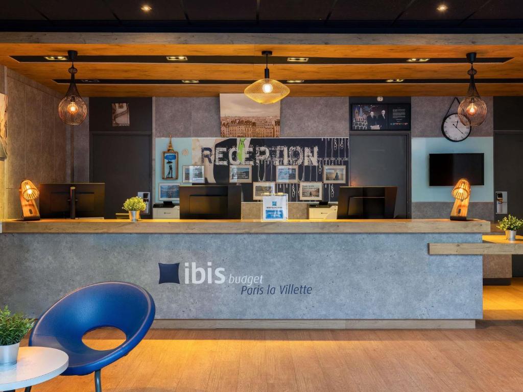 a restaurant with a reception counter with a blue chair at ibis Budget Paris La Villette 19ème in Paris