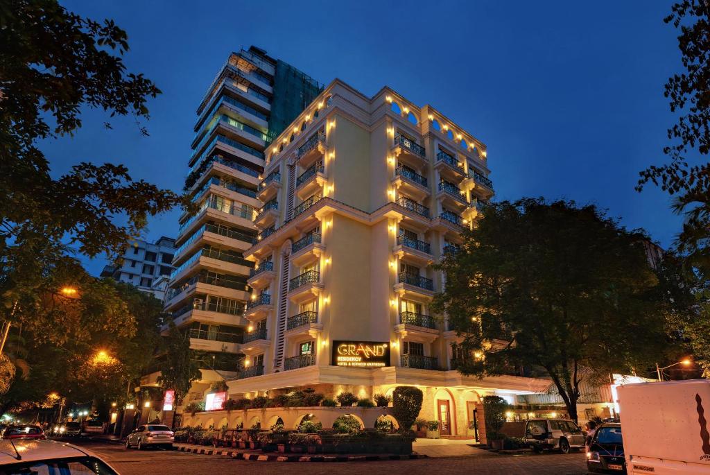 un gran edificio blanco con luces encendidas en Grand Residency Hotel & Serviced Apartments en Bombay