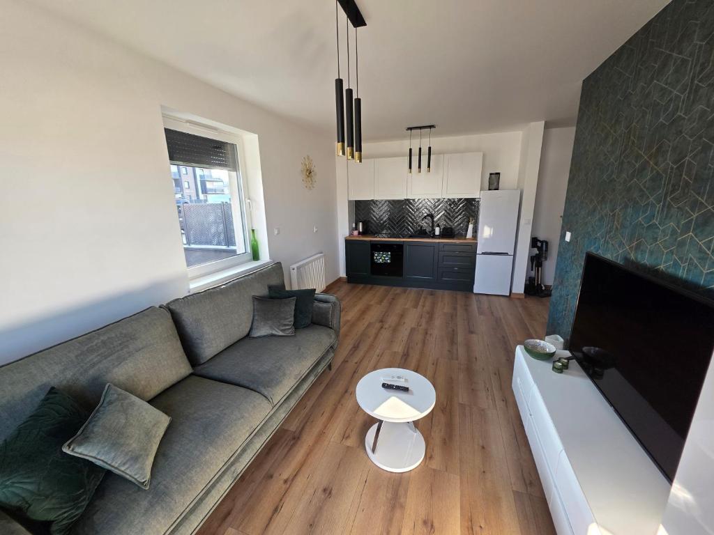 a living room with a couch and a table at Apartament Podmiejska Nova in Kalisz