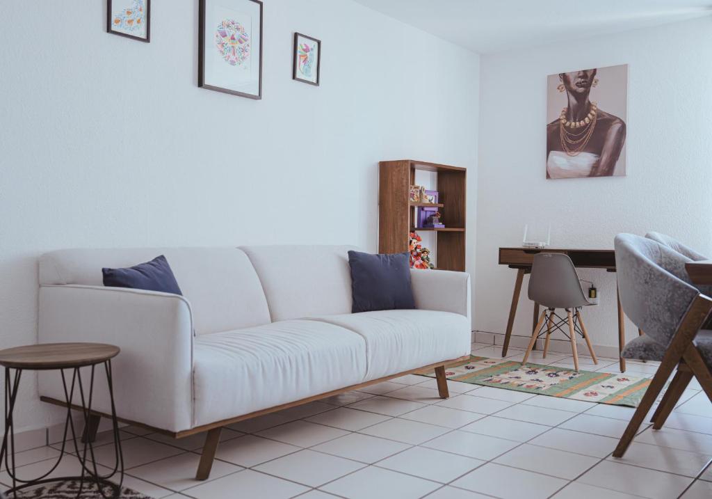 a living room with a white couch and a table at Viveros Centric and Comfortable Apt 2BR B Quintana Alamos in Laborcillas