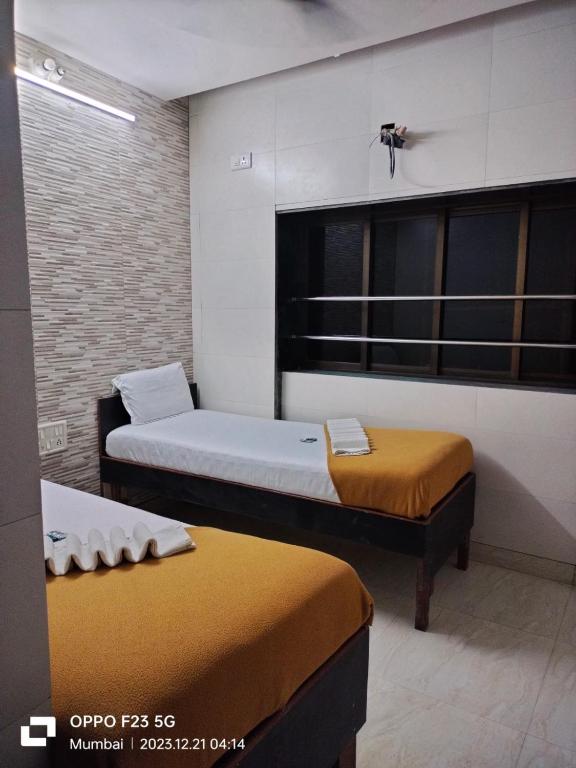 a room with two beds in a room at Hotel Kamal in Mumbai