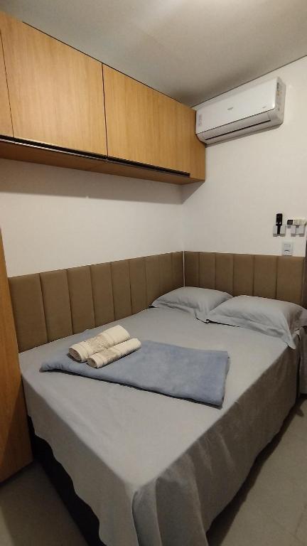 a bed with a blue blanket on top of it at Studio moderno e bem localizado in João Monlevade