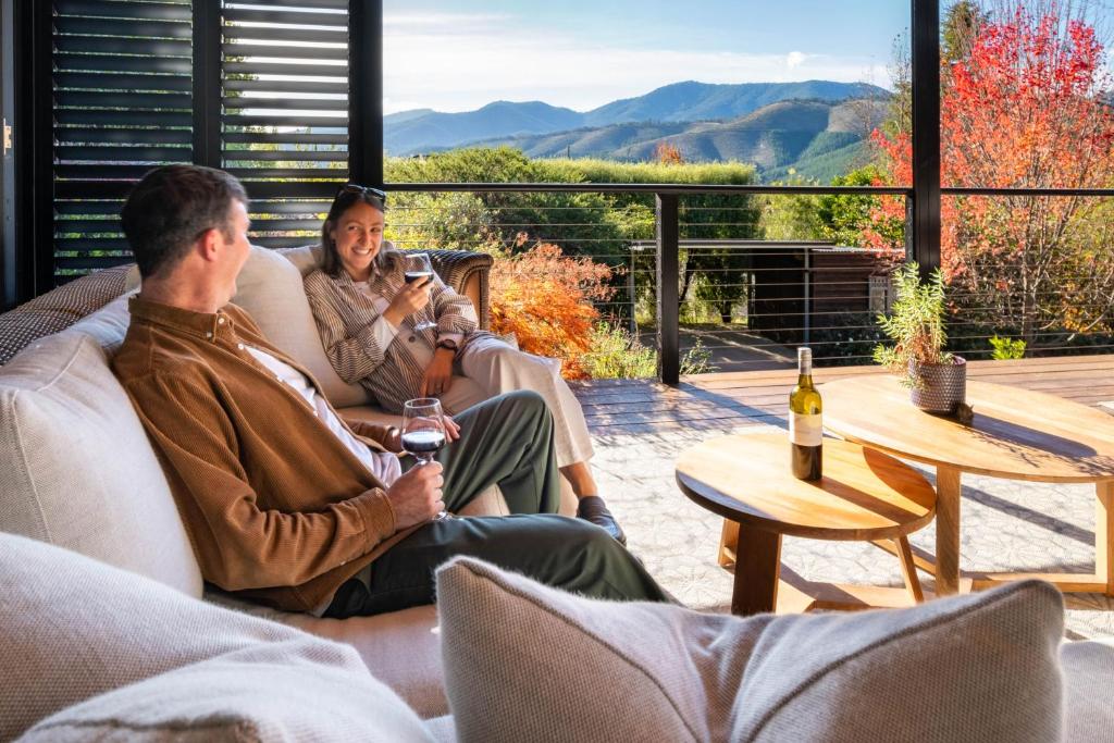 two men sitting on a couch drinking wine at 25 Walkers Lane in Bright