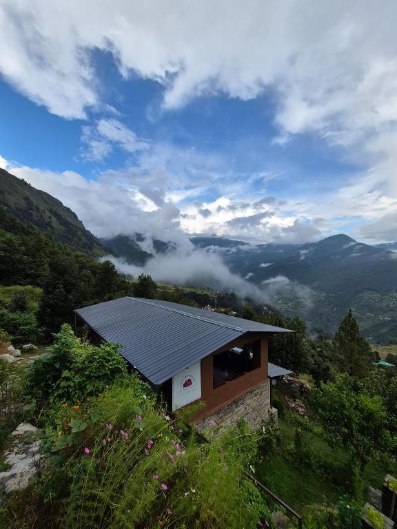 a house with a roof on top of a mountain at Buransh Stays - Sari in Sari