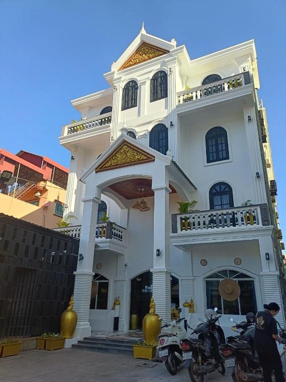 two motorcycles parked in front of a white building at Parent Heritage Angkor Villa in Siem Reap