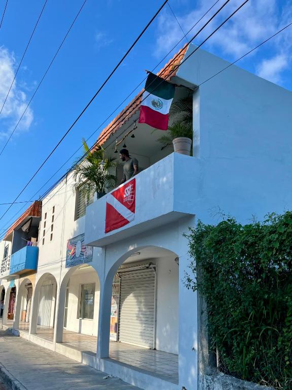 ein weißes Gebäude mit Flaggen auf dem Dach in der Unterkunft Mi Refugio Dive House in Cozumel