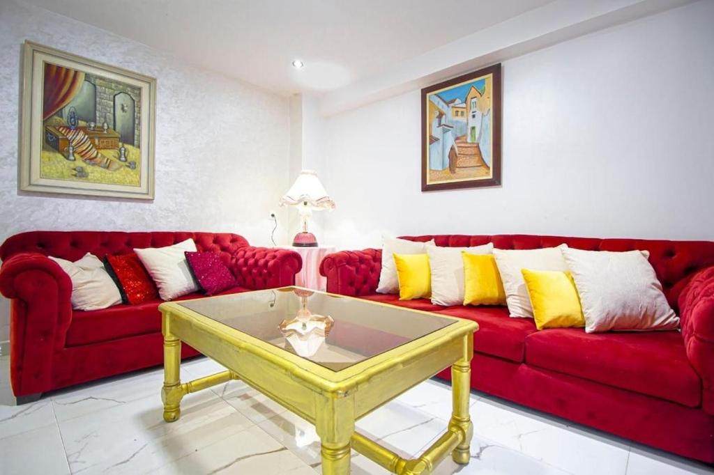 a living room with red couches and a yellow coffee table at Maison Cozy à Tanger in Tangier