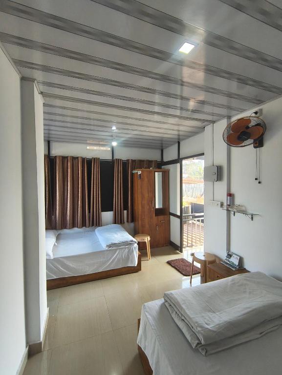 a bedroom with two beds and a balcony at Sleek Haven in Meppādi