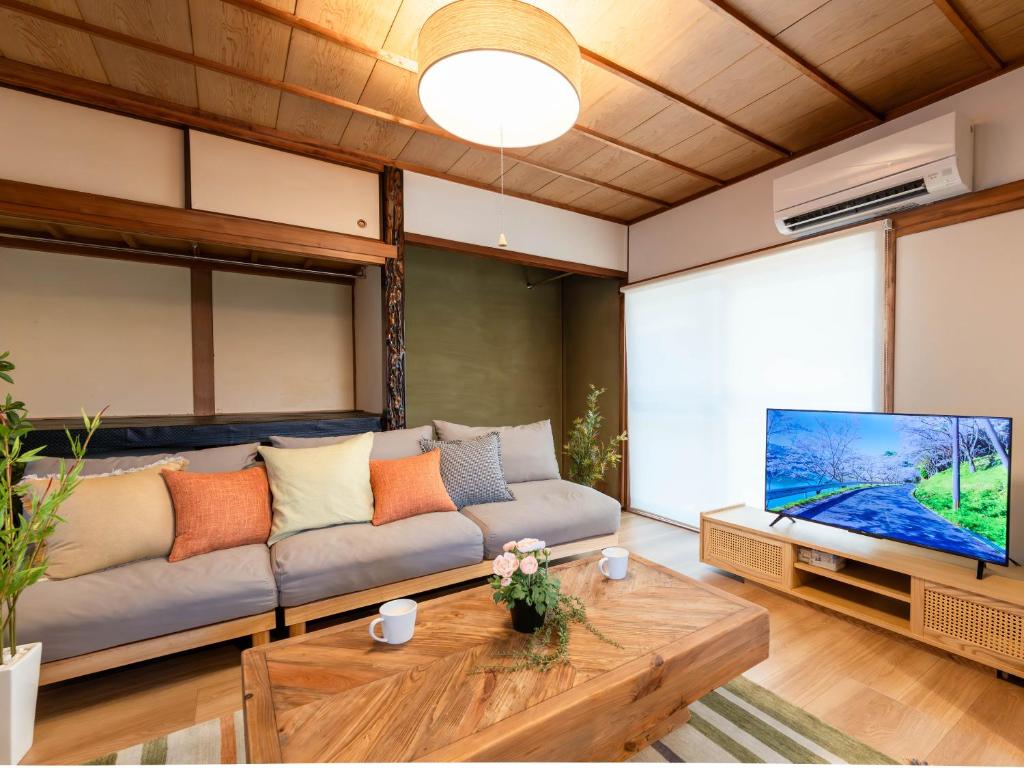 a living room with a couch and a flat screen tv at 屋島base-最大10名 in Takamatsu