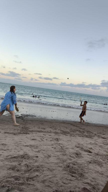 a woman and a child playing frisbee on the beach at Flat Beira Mar 331 - 424 - 426 in João Pessoa