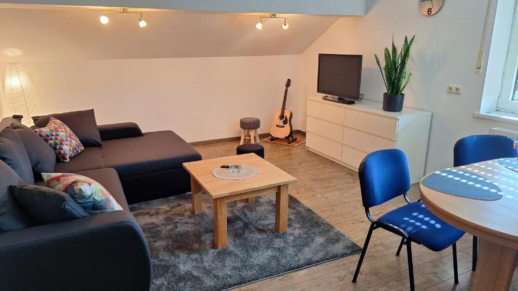 a living room with a couch and a table at Sunset Apartment in Grafenwöhr