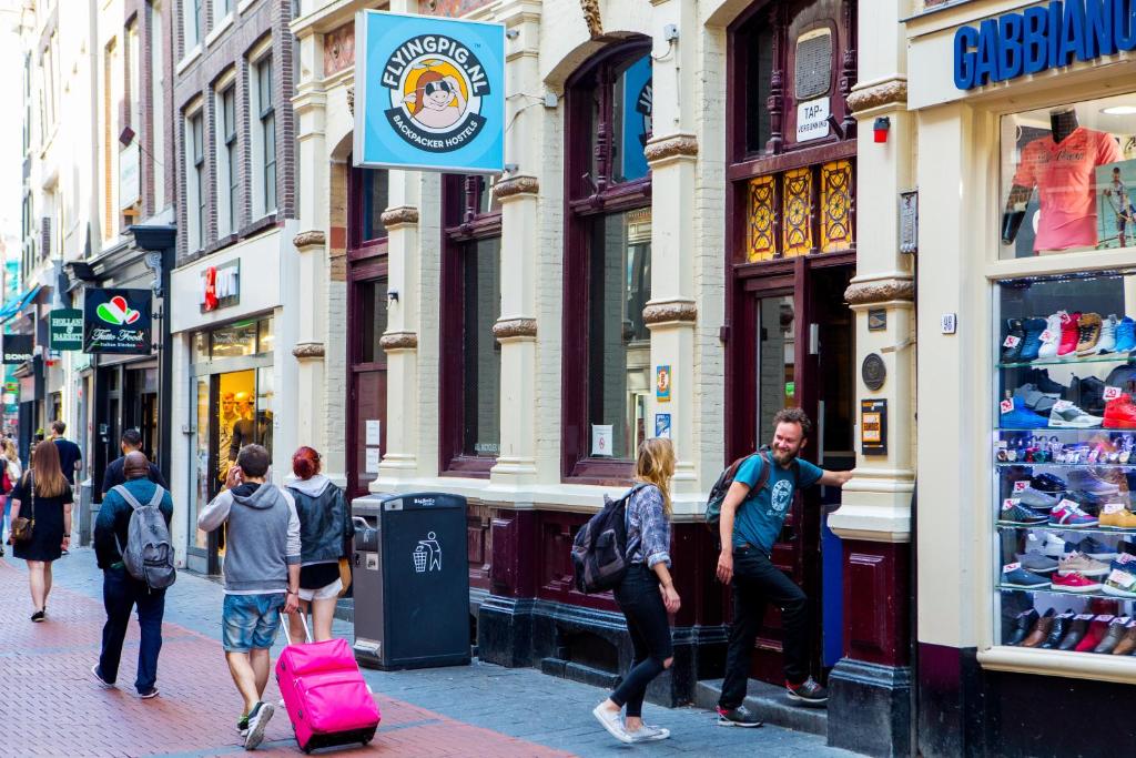 um grupo de pessoas andando por uma rua da cidade em The Flying Pig Downtown em Amesterdão