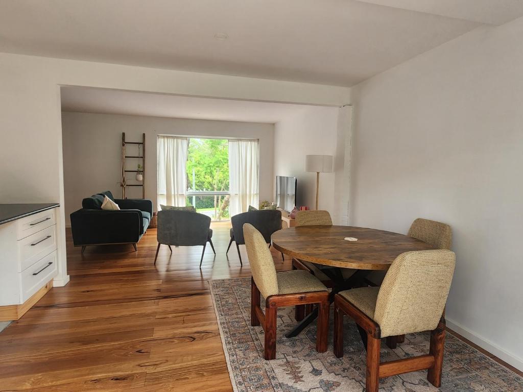 a living room with a wooden table and chairs at Saltwater Daze - Hosted in Sunshine Bay