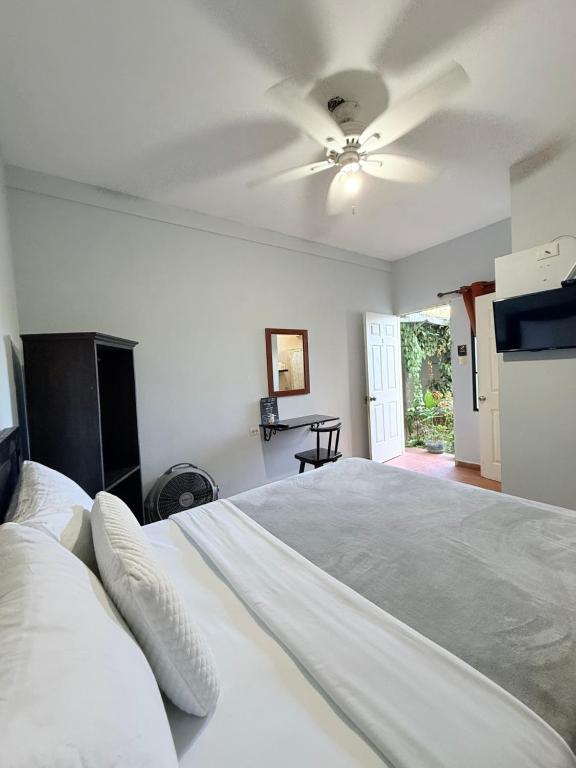 a bedroom with a large bed with a ceiling fan at Los Portones de Ataco in Concepción de Ataco