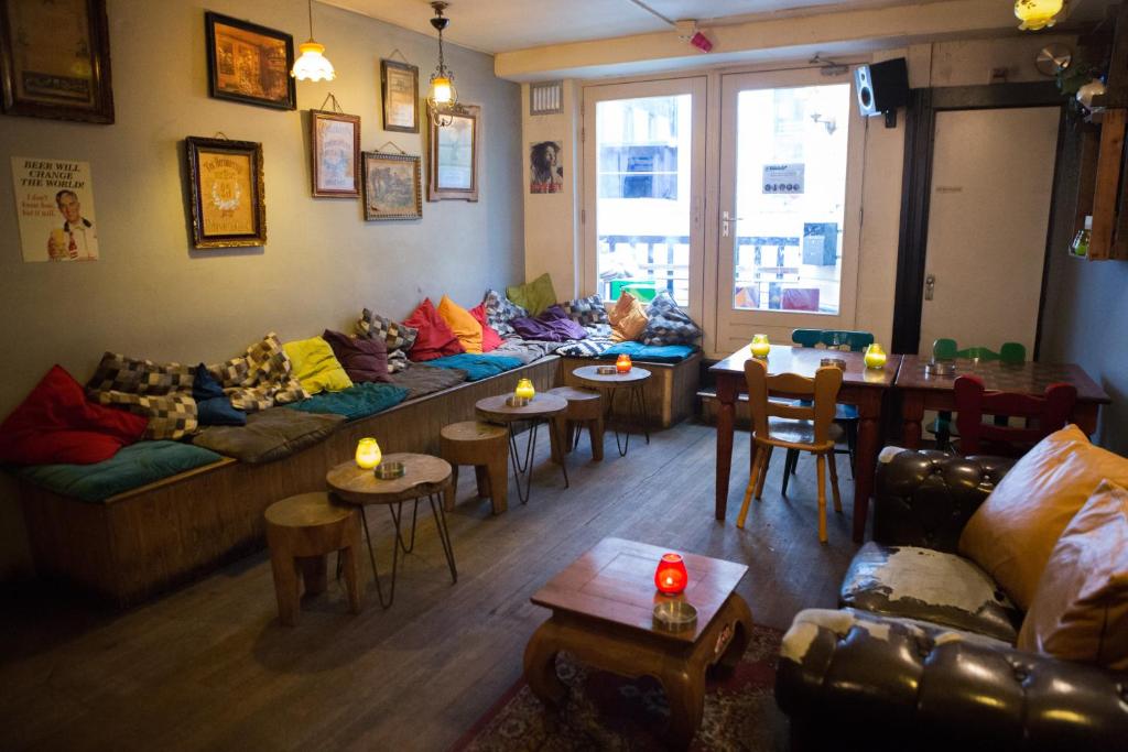 un soggiorno con divani, tavoli e sedie di The Flying Pig Downtown ad Amsterdam