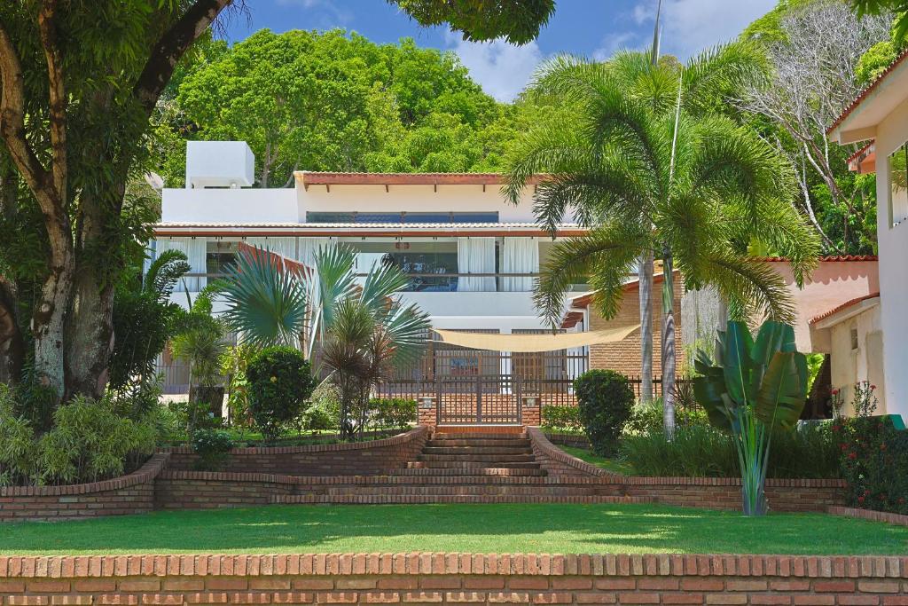 a house with stairs and palm trees in front of it at Casa Maravida in Maragogi