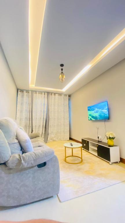 a living room with a couch and a flat screen tv at Urban Host Buru Prime 1BR Luxe in Nairobi