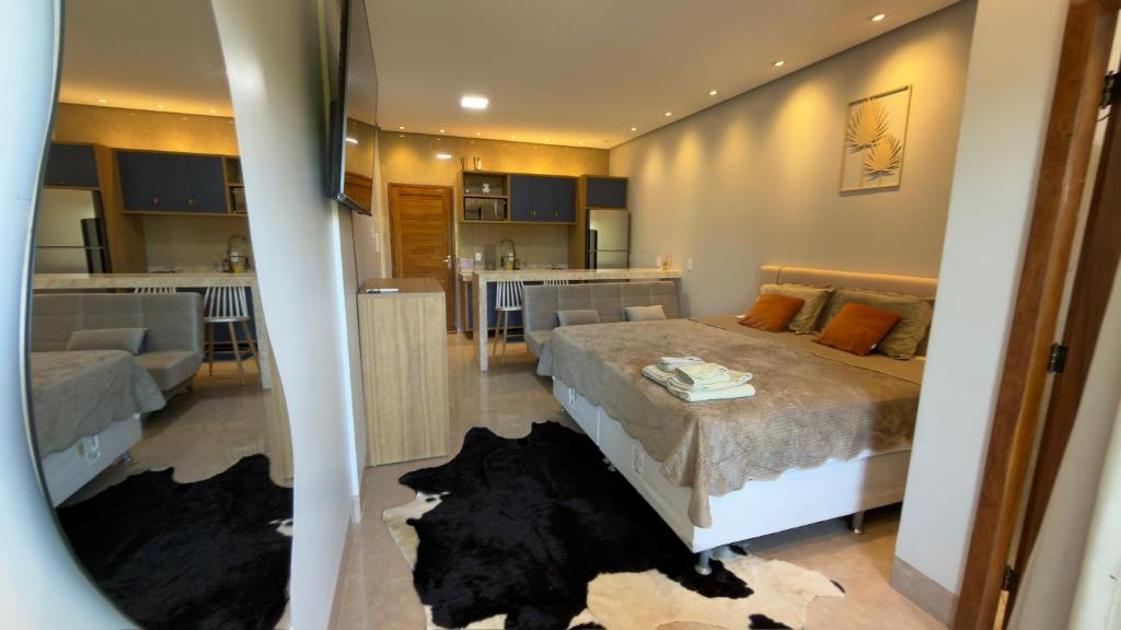 a bedroom with a large bed and a kitchen at Flat 213 Ilha Bela Alter do Chão in Alter do Chao