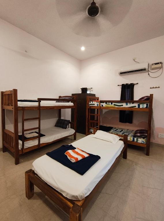 a room with three bunk beds in a room at Art cafe in Auroville