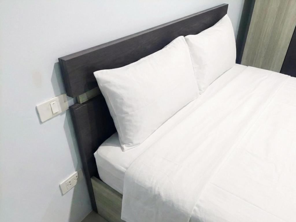 a close up of a bed with white sheets and pillows at Heimat Garden Homestay in Ban Lo Pa Ret