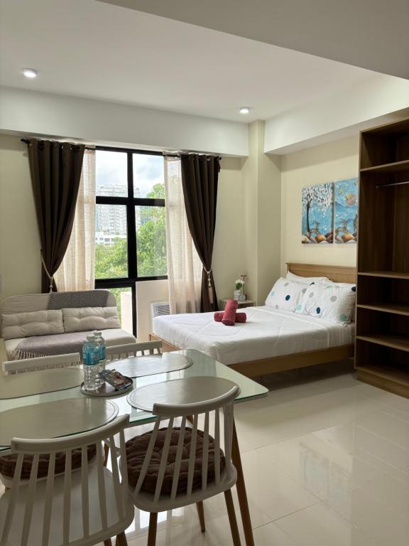a bedroom with a bed and a table and chairs at Mactan Plains Studio Unit in Punta Engaño