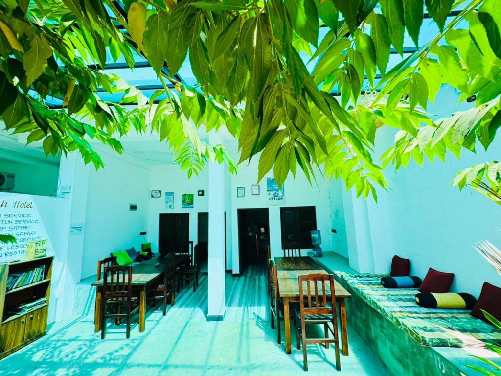 a living room with a couch and a table and chairs at Surf Bay Hotel in Arugam Bay