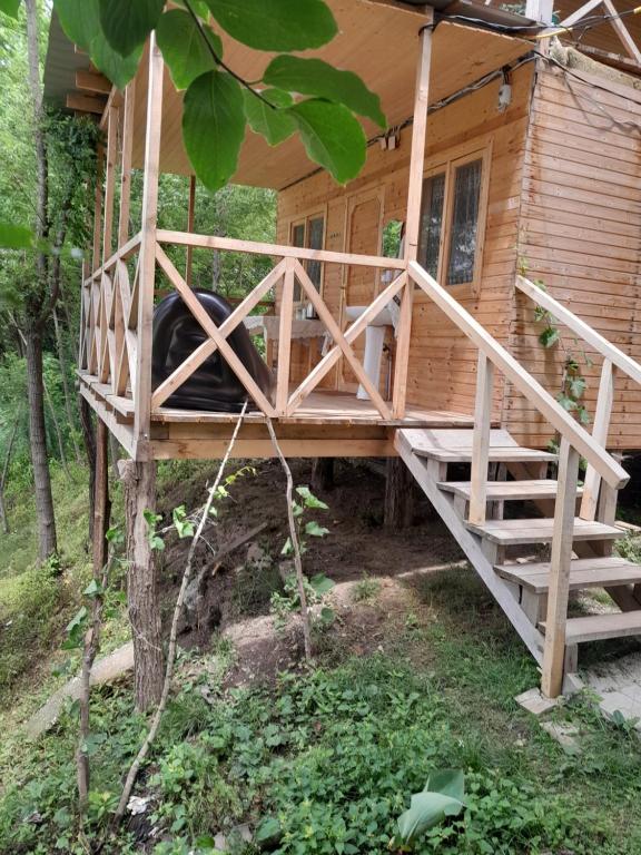 a tree house with a porch and stairs to it at Riverside Nature in Martvili
