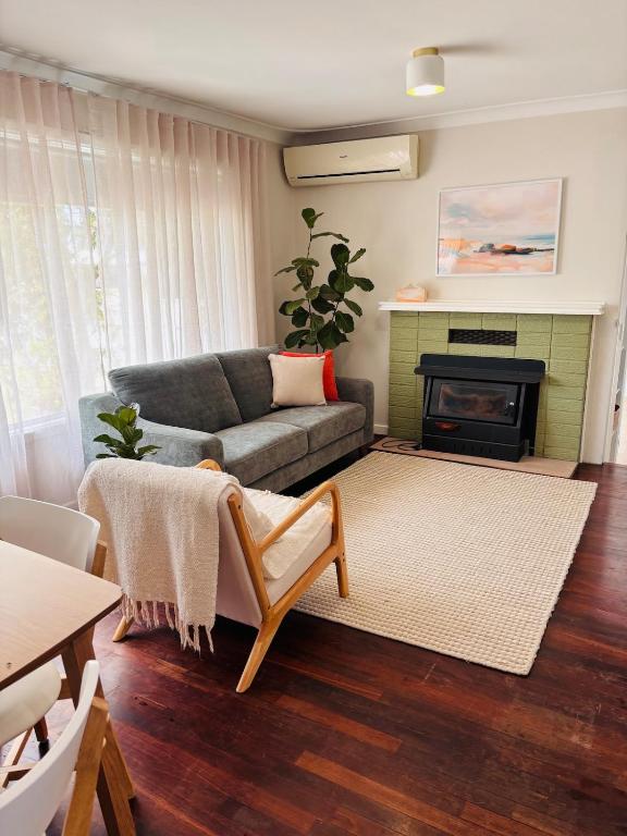 a living room with a couch and a fireplace at Esperance Seaside Cottage in Esperance