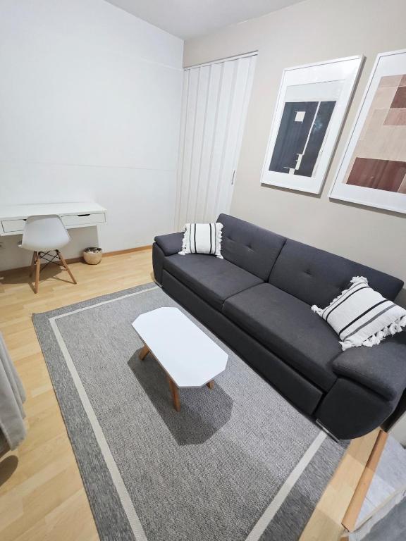 a living room with a black couch and a table at Cozy Apartamento en Puebla! in San Baltasar