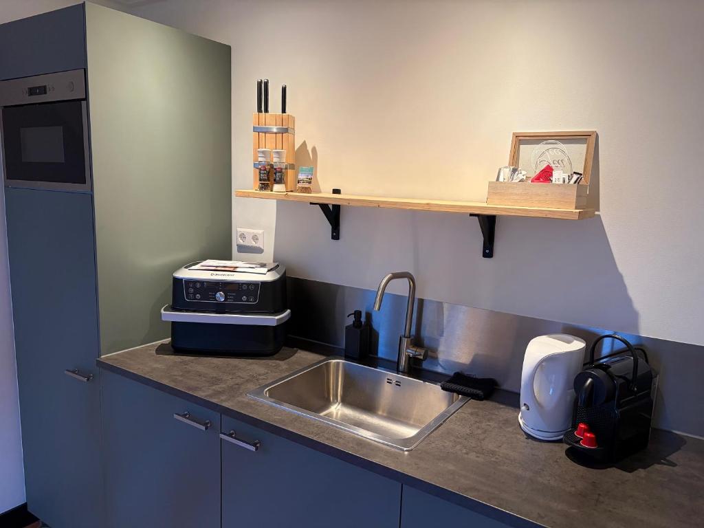 a kitchen with a sink and a counter top at De Danser 2 in Klaaswaal
