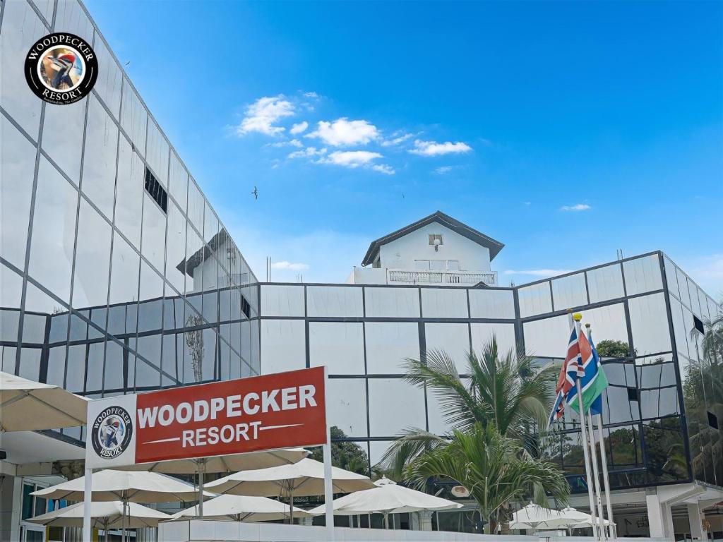 a building with a sign in front of a resort at Woodpecker Resort Hotel in Banjul