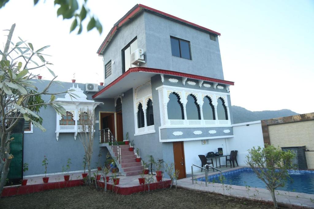 a house with a swimming pool in front of it at The Gold Mount Villa in Udaipur