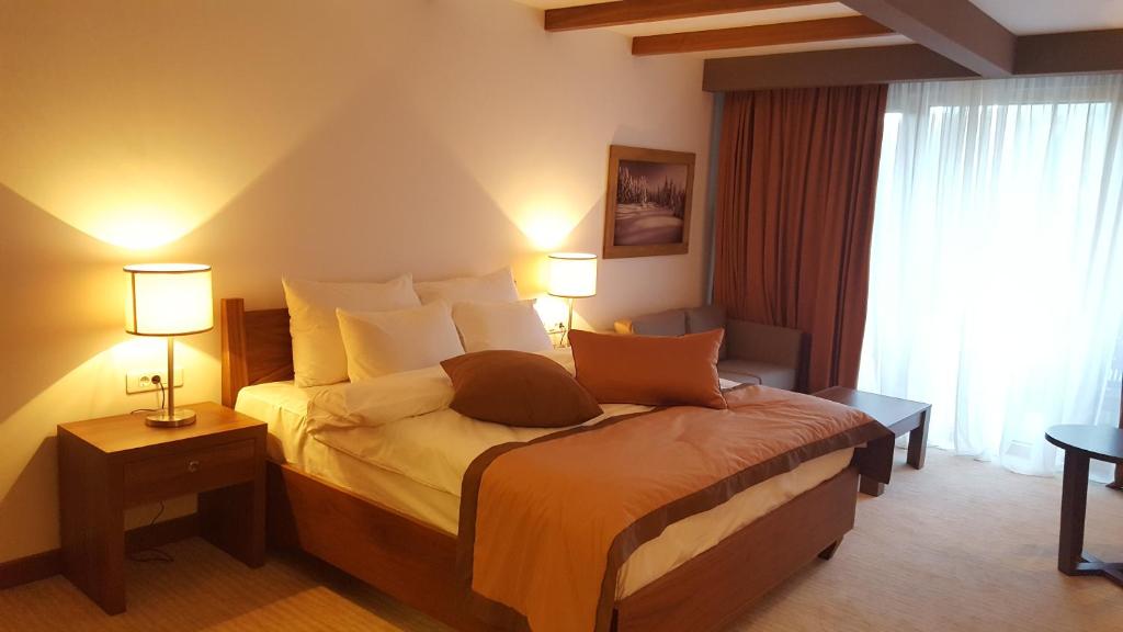 a bedroom with a bed with two lamps and a window at Jahorina Apartment 226 in Aparthotel Vucko in Jahorina