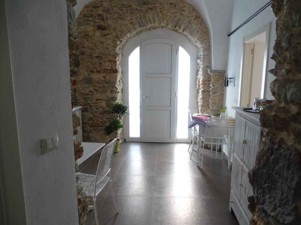 einen Flur mit einer weißen Tür und einer Steinmauer in der Unterkunft Ca Du Ventu in Carbuta