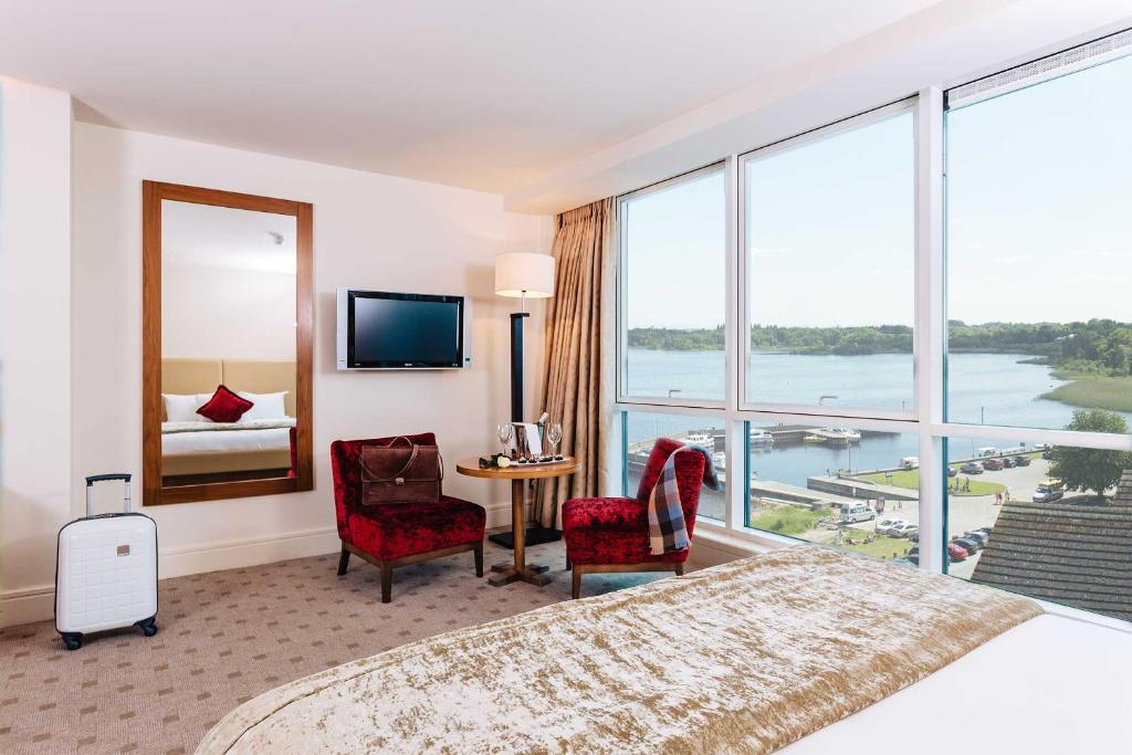 um quarto de hotel com uma cama grande e uma janela grande em Hodson Bay Hotel em Athlone