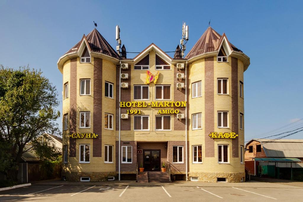 a large yellow building with a sign on it at Marton Amigo Krasnodar in Krasnodar