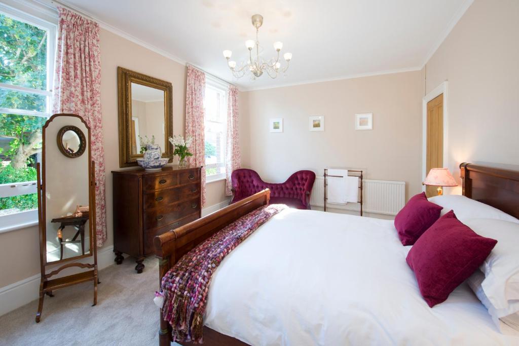 a bedroom with a large bed and a mirror at Lamb's Knees in Seaford