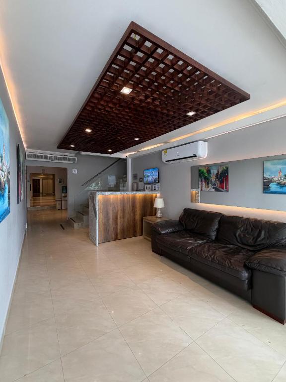 a lobby with a leather couch and a bar at Hotel Amoek in Cartagena de Indias