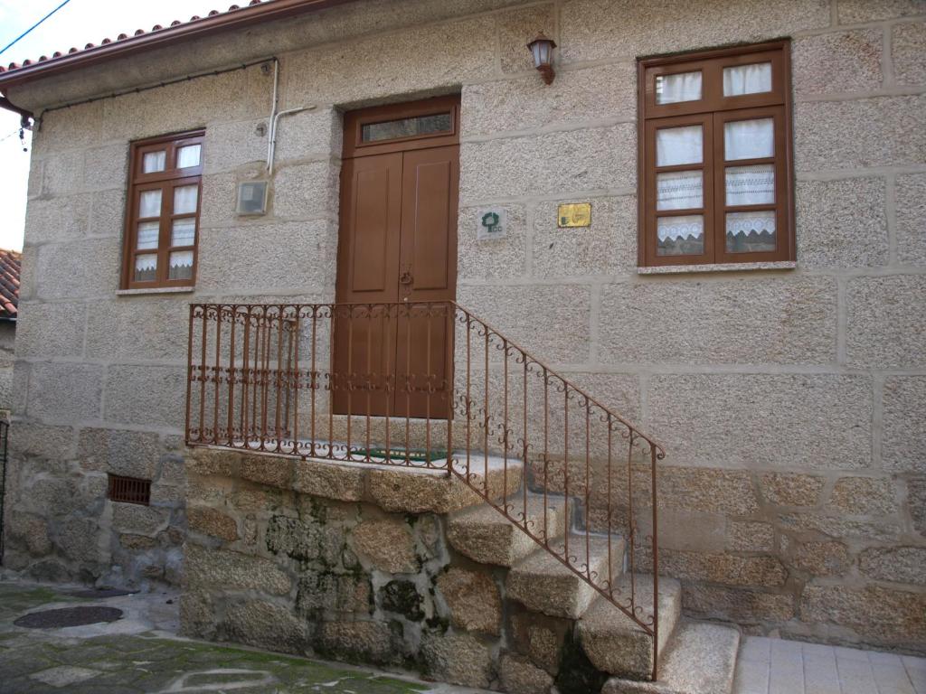 Casa de piedra con puerta de madera y escaleras en Casa de RioBom, en Soajo