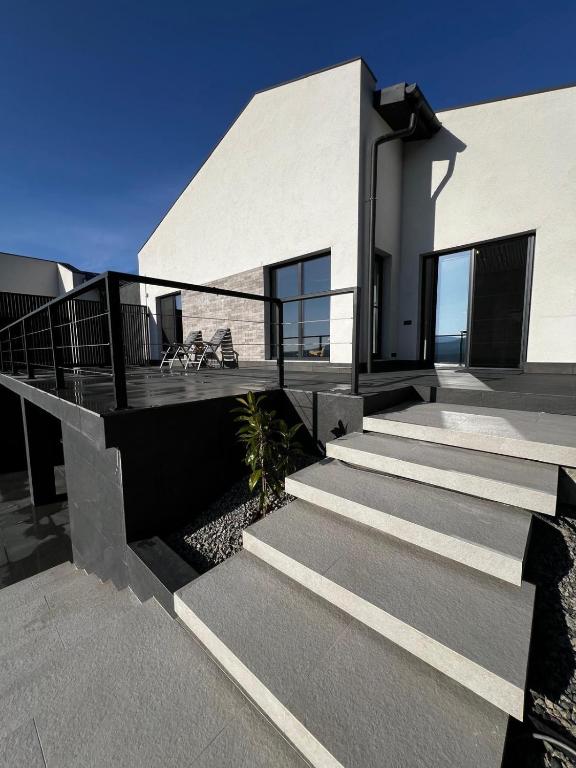 a modern house with stairs leading to a balcony at Mountain View Home in Zalău