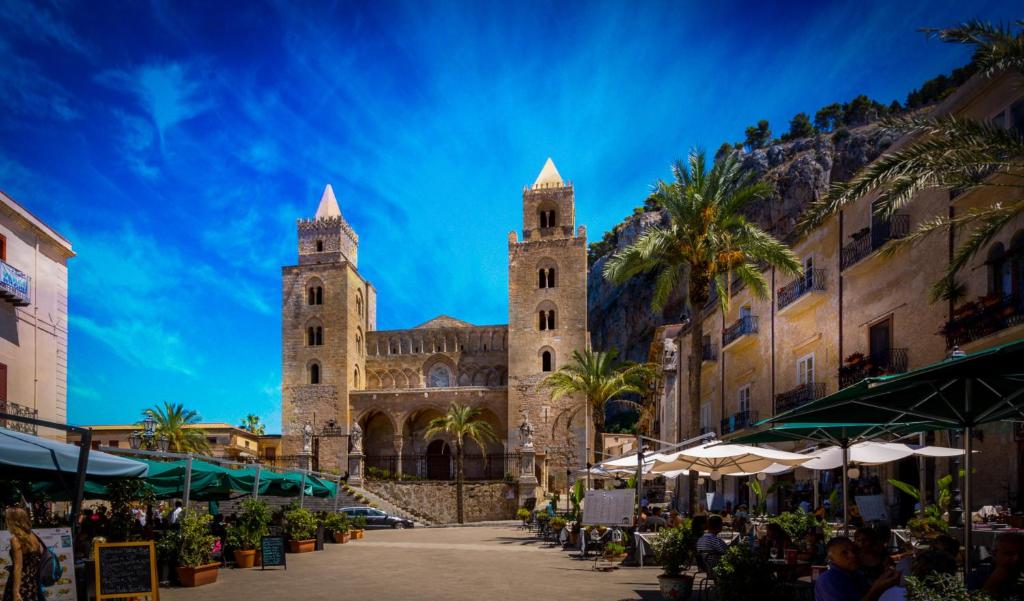 kościół z dwoma wieżami z palmami przed w obiekcie Porto Salvo Apartments - by Vacation Service w Cefalù