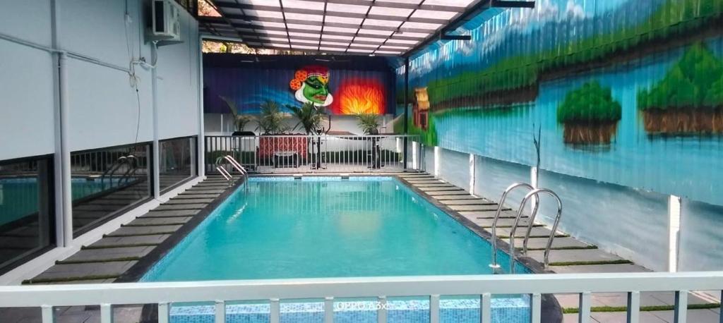 a swimming pool in a building with a mural on the wall at Casa Resort in Payyannūr