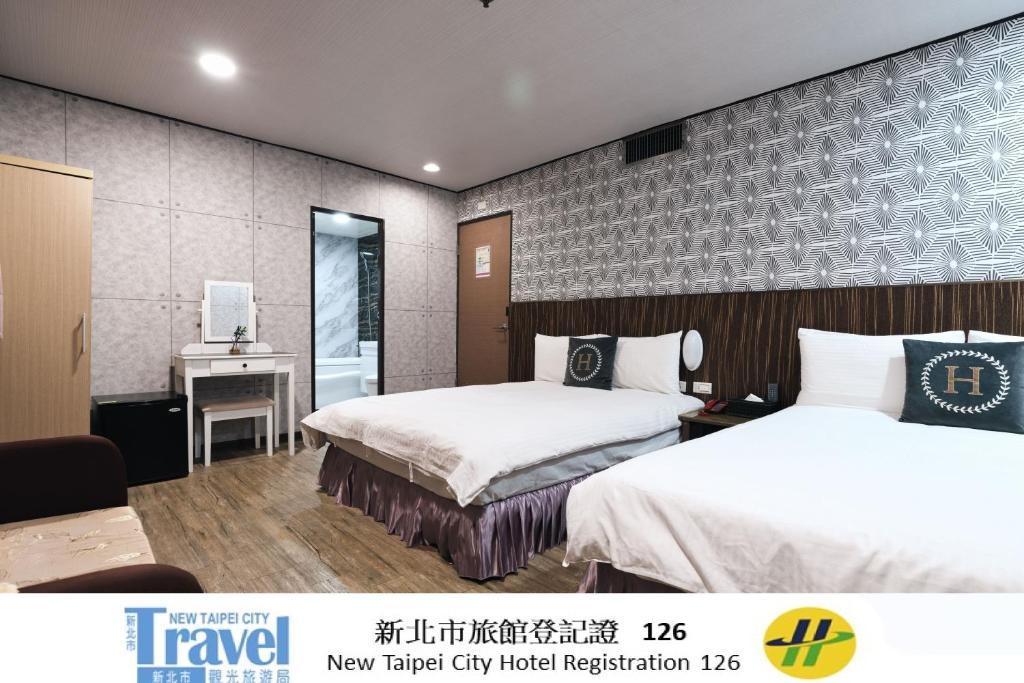 a hotel room with two beds and a desk at Sofu Hotel in Taipei
