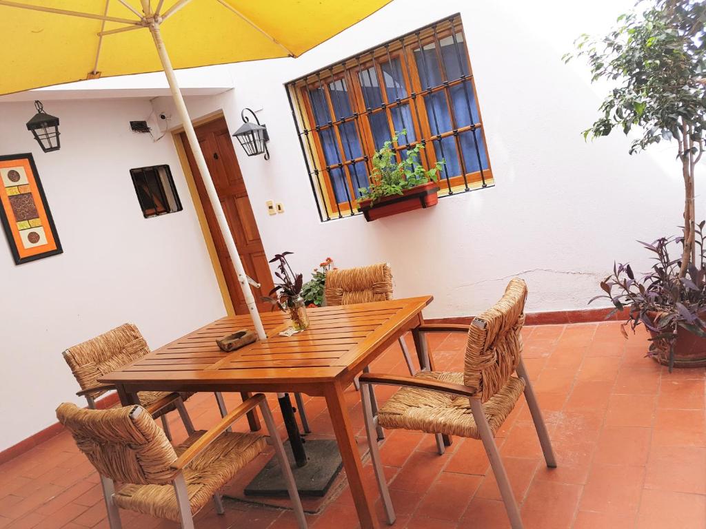 a wooden table with chairs and an umbrella at Azul Departamentos in Mendoza