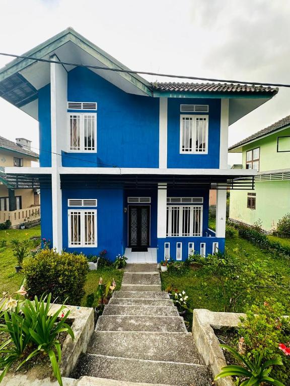a blue house with stairs in front of it at Vila Biru Gundaling Brastagi in Berastagi